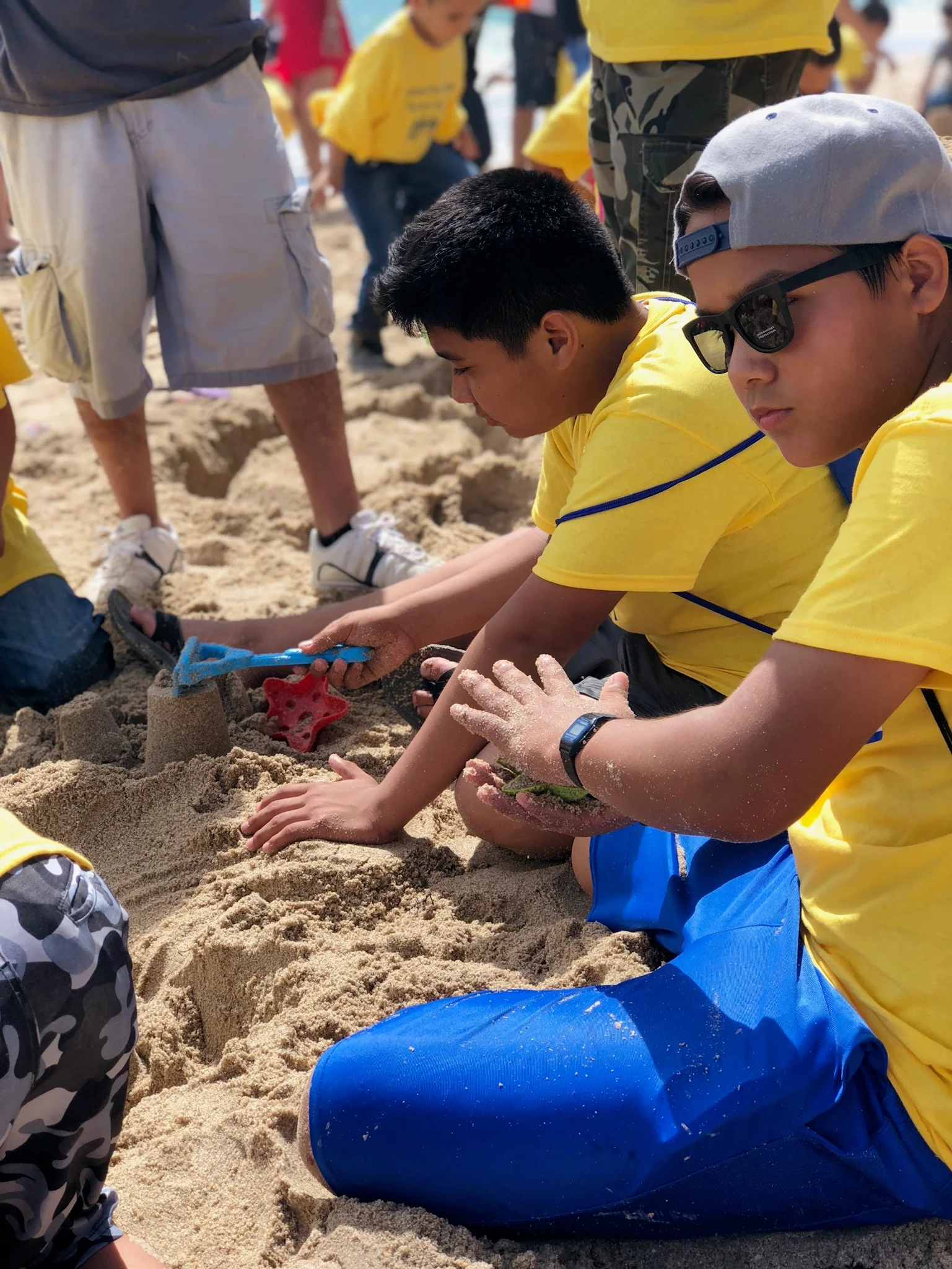 A volunteer helping a child build in the sand