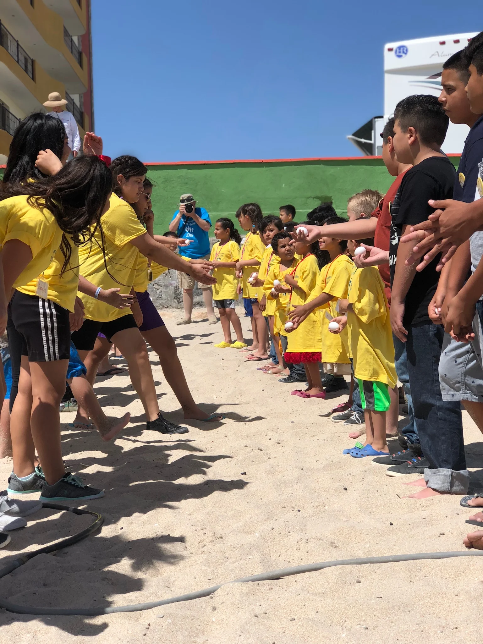Children and volunteers taking part in games on the beach